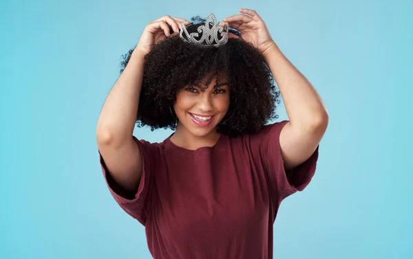 stock image Wear your confidence like a queen wears her crown. Studio shot of a young woman putting a crown her head against a blue background