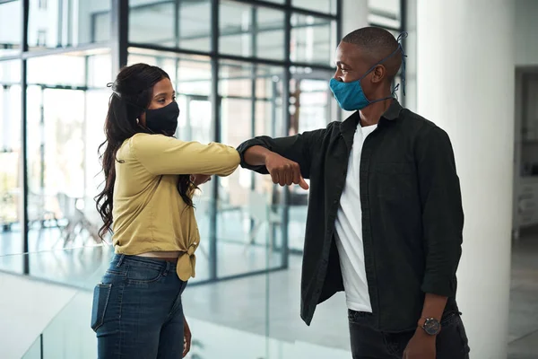 stock image In a world where we only say goodbye. two young people safely greeting one another during a pandemic in a modern office