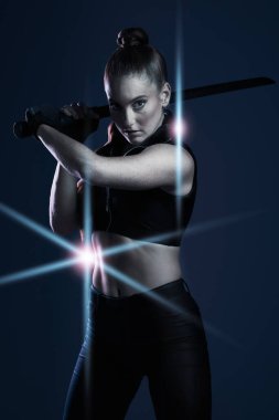 Savaşçı, kadın ve kılıç portresi karanlık arka planda hareket için stüdyoda savaşacak. Güçlü bir kadın model, suikastçı ya da ajan bilimkurgu fütüristik kostümlü ve Ninja ya da Kanunsuz olarak görev yapan.