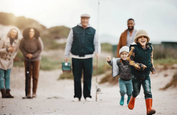 Running, happy and family at the beach for fishing, hobby and weekend activity. Carefree, freedom and children, parents and grandparents playing by the ocean and ready to catch fish for recreation.