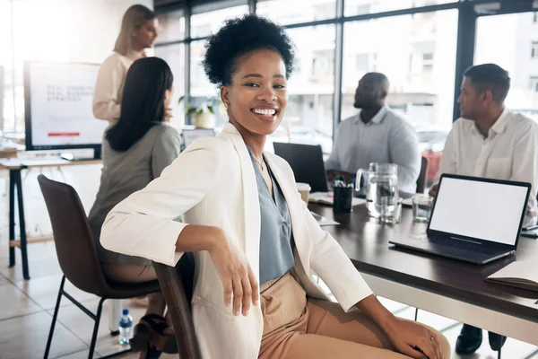 Portrait, meeting and a black woman in a business boardroom with her team for a strategy presentation on laptop mockup screen. Workshop, training and collaboration with a female sitting at a table.