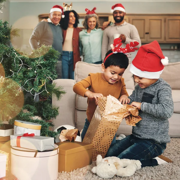 Christmas, excited and children opening gifts, looking at presents and boxes together. Smile, festive and kids ready to open a gift, or present under the tree for celebration of a holiday at home.