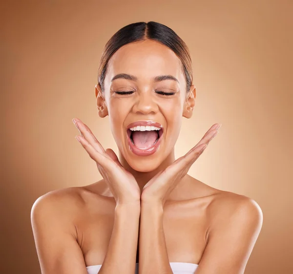 Beauty, excited and a woman with hands on face for skin care glow and shine in studio on brown background. Aesthetic female model with eyes closed for spa facial, dermatology cosmetic and wellness.