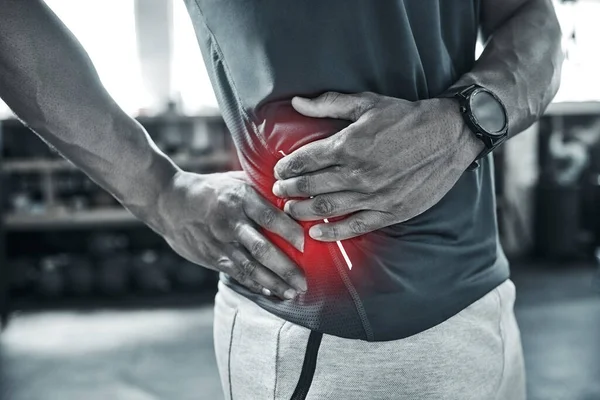 紧臀对疼痛没有好处 髋关节疼痛的健美运动员 肌肉疼痛在锻炼身体时很常见 在体育馆里 教练用手触摸腰部疼痛时的身体闭锁 — 图库照片