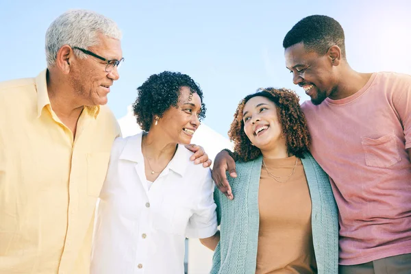 stock image Happy family, couple and parents on vacation or holiday bonding together smile and having fun outdoors. People, man and woman embrace with mother and father as love, care and support during weekend.