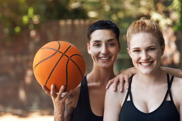 俺達には試合とボールがある バスケットボールコートの上に二人の魅力的な若い女性選手のトリミング肖像画 — ストック写真