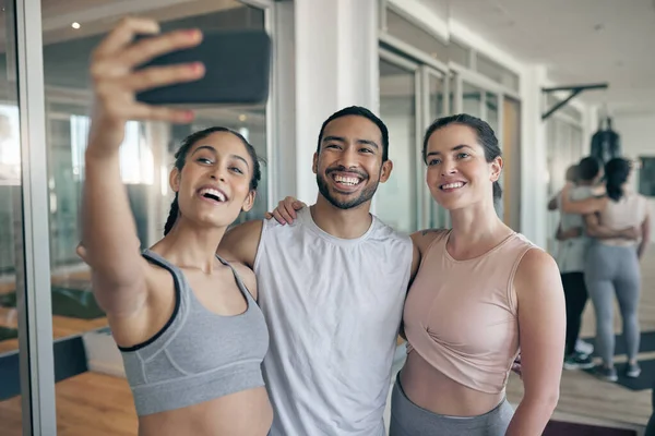 Sending some fitness motivation your way. three young athletes taking a selfie while standing together in the gym
