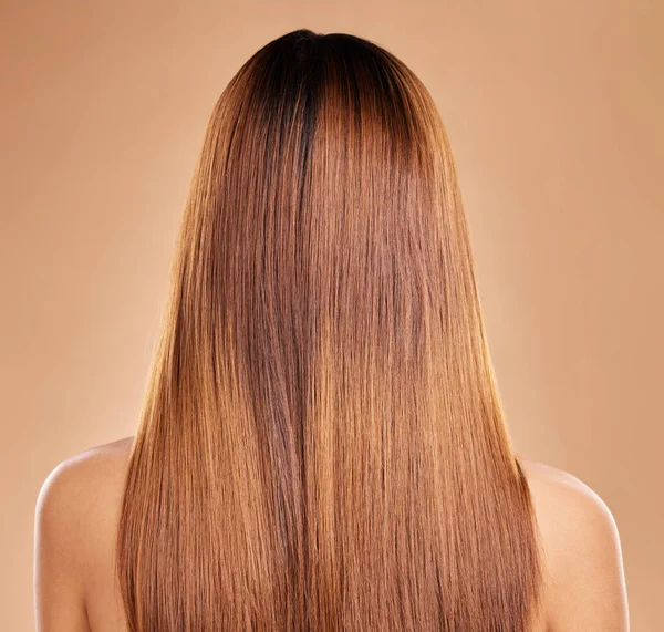 Haircare, beauty and back of woman with straight hair in studio isolated on brown background. Balayage, wellness and female model with salon treatment for growth, keratin texture or healthy hairstyle.