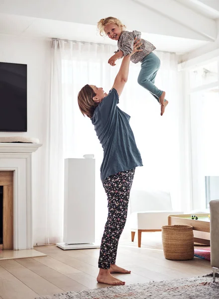 Catch me Mom. Full length shot of an attractive young mother and playing with her daughter in the living room at home