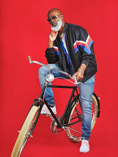 メモリーレーンを下りましょう 赤い背景をしたヴィンテージの自転車に座っている先輩が — ストック写真