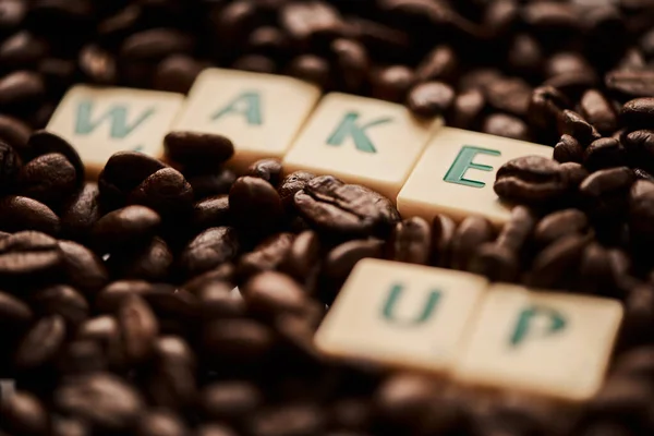 Waking up to a brew-tiful day. Closeup shot of block letters forming the words wake up on a pile of coffee beans