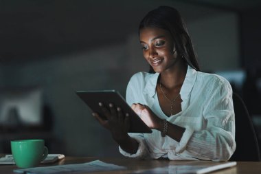 Senin de bağlanma zamanın geldi. Geceleri ofiste dijital tablet kullanan genç bir iş kadını.