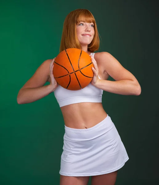 今天枯燥无味 明天更坚强 一位年轻貌美的女运动员独自站在演播室里 拿着一个绿色背景的篮球 — 图库照片