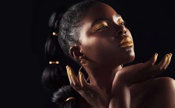 Put gold next to melanin, and melanin will stand out. Studio shot of a beautiful young woman wearing make up and jewellery against a black background