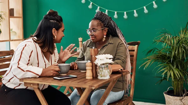 Make sure to make time for your friends. two young women chatting at a cafe