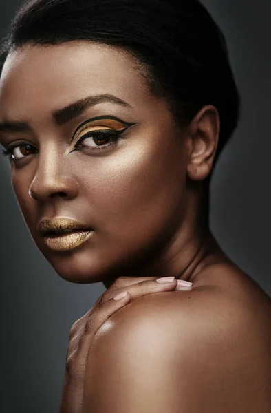 stock image No one is you and thats your power. a beautiful young woman wearing gold makeup against a grey background