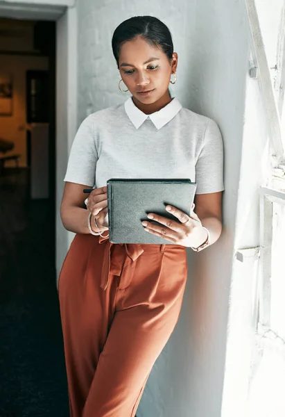 Developing new ideas through the digital space. a young businesswoman using a digital tablet in an office