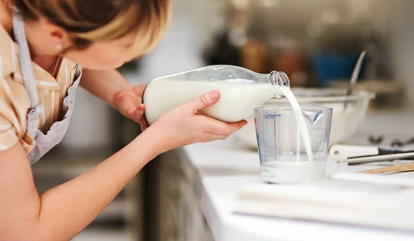 stock image Make sure you get the correct measurements. a young woman measuring milk while baking at home