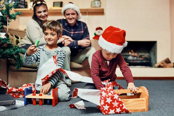 크리스마스 아침은 장난감가게 스러운 부모와 집에서 크리스마스 선물을 포장하고 있습니다 — 스톡 사진