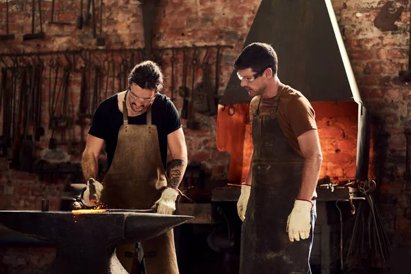 人对铁 两名年轻英俊的金属工人在一个焊接车间里一起工作 — 图库照片