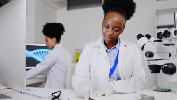 Científico Microscopio Mujer Negra Escribiendo Investigación Resultados Información Laboratorio Ciencia — Vídeo de stock