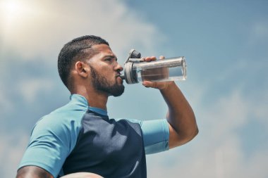 Bir spor adamı ile su içmek, spor yapmak ve antrenman yapmak yarışma ya da etkinlik için açık havada. Erkek bir sporcuyla egzersiz, su ve sağlık molası sırasında ya da dinlenirken şişeden su içen..