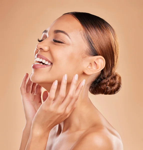 Smile, beauty and a woman with hands on face for skin care glow and shine in studio on brown background. Aesthetic female model laugh and satisfied with spa facial, dermatology cosmetic and wellness.