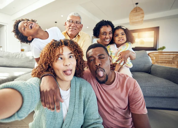 Comic, selfie and grandparents with parents and children in living room to relax, bonding and quality time. Love, home and photo portrait of happy family and kids smile, funny face and laugh together.