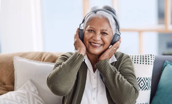 老式曲调是我的风格 在家里听音乐时戴耳机的老年妇女的画像 — 图库照片