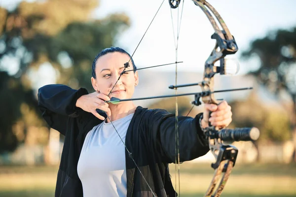 Woman, bow or arrows aim in sports field, shooting range or gaming ground for hunting, hobby or performance exercise. Person, archery or athlete and weapon in target training, competition or practice.