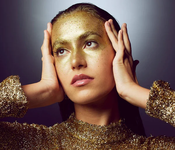 Glitter, gold and makeup with woman in studio for fashion, beauty and creative art. Glamour, trendy and cosmetics with female isolated on black background for luxury, elegance and shimmer sparkles.