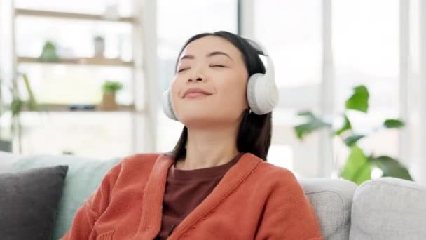 音频和女人放松地坐在沙发或沙发上听着家里的歌曲 享受着公寓里的收音机 在客厅里快乐快乐的年轻人在用耳机玩乐 — 图库视频影像