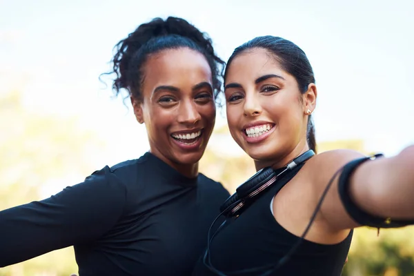 Creating memories. Cropped portrait of two attractive young women posing for a selfie after their run together in the park