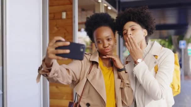 城市里的黑人妇女 朋友和自私自利者 带着微笑 和平标志或滑稽的脸亲吻 舌头和户外 供社交媒体 摄影或人行道上的人物形象图片用的地铁中的女孩 妇女和街道 — 图库视频影像