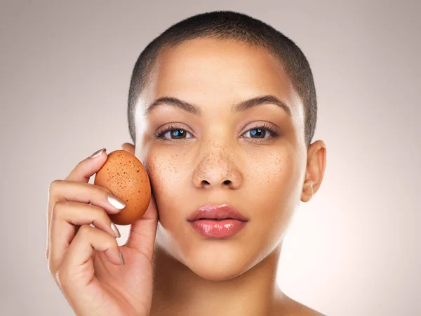 stock image Different is beautiful. Studio shot of a beautiful young woman holding a egg against her face