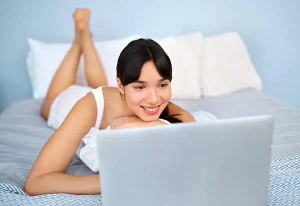社交媒体时间 一个快乐迷人的年轻女人白天躺在床上在笔记本电脑上浏览 — 图库照片