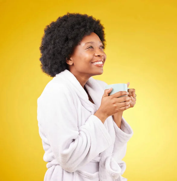 Happy, coffee and relaxed black woman in studio, waking up and smile on yellow background space. Carefree, relax and female with tea in bathrobe, satisfied and cheerful, stress relief and isolated.