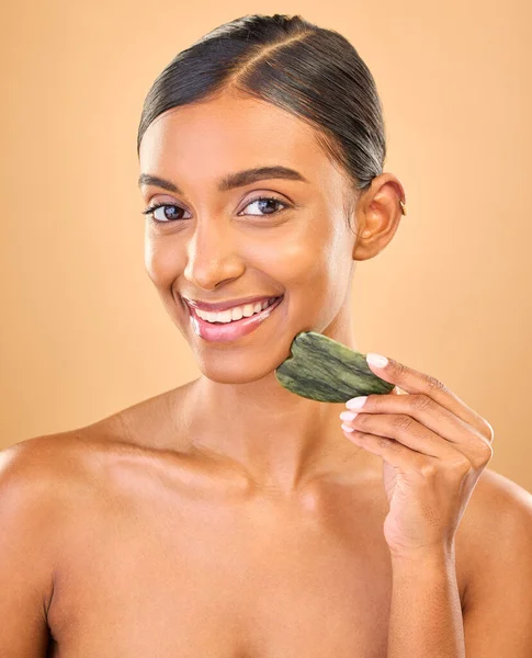 面对微笑 护肤和女人与瓜沙在工作室孤立的褐色背景 用翡翠水晶或石头制作的皮肤科肖像 按摩和快乐的印度女模 用于健康的皮肤治疗 — 图库照片