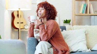 Relaxing, drinking and thinking African American woman daydreaming enjoying coffee, tea or cosy beverage while calm at home. Casual, leisure and female alone in relaxed environment taking a break