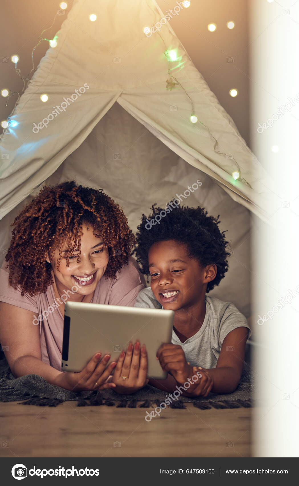 Duas Meninas No Sofá à Noite Com Um Tablet Digital. Jogos Online