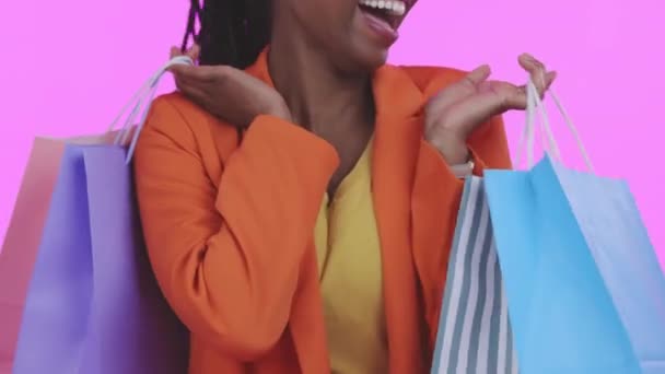 ピンクのスタジオの背景に対して小売 ブティックアイテムと顧客との閉鎖 黒の女性とバッグ ズーム アフリカ系アメリカ人女性と高価な服 購入と販売でファッションとクライアント — ストック動画