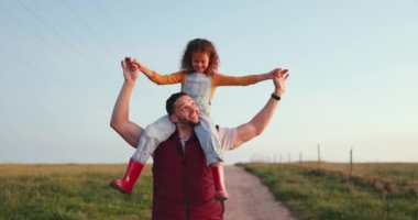 Mutlu aile, baba ve çocuk rahat, sakin ve huzurlu bir tatilde çiftlikte yürüyor. Gülümse, mutluluk ve genç kız bağlanmaktan ve babasıyla doğa alanında eğlenmekten hoşlanıyor..