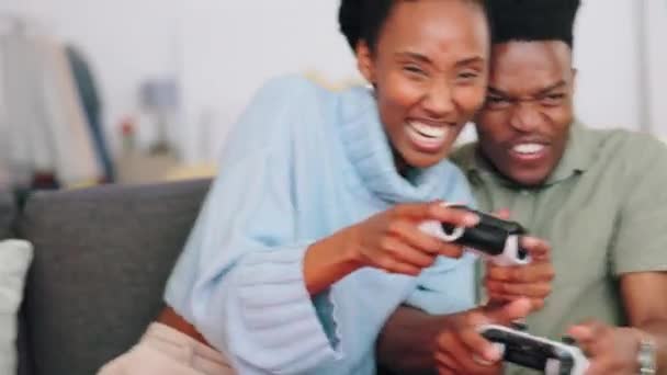 クレイジーカップルは ビデオゲームをプレイし 自宅で一緒にオンラインゲームを楽しんでいます 面白いです黒男と女性保持ジョイスティックコントローラーリラックスして楽しんで彼らのフリーレジャー休憩時間オンザソファ — ストック動画
