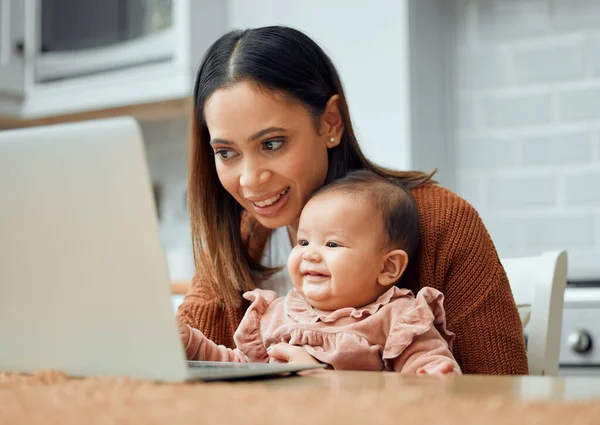 The best company for a working mom. Cropped shot of an attractive young woman working at home with her newborn baby sitting on her laptop
