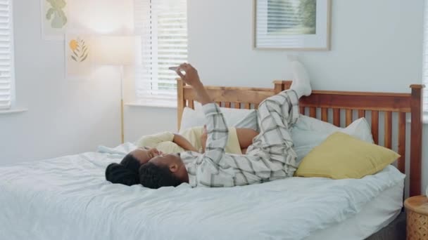 아프리카 커플은 전화로 침대에 평화롭고 편안하고 행복해 침실에서 모바일에서 사진을 — 비디오