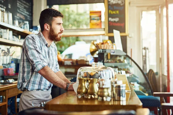 最初の顧客が歩くのを待っている 喫茶店で働いている若い男が — ストック写真