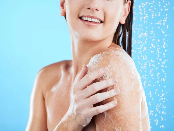 洗澡时 女人的手和笑容都在工作室里洗净 而女人的洗净则是为了美感 蓝色背景的人在浴室里进行自我护理和皮肤科护理的水 模型肩及健康状况 — 图库照片