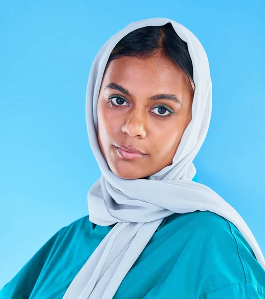青い背景 スタジオと背景にスカーフでイスラム教徒 深刻な女性と肖像画 若い女性モデル イスラム文化とエンパワメントの美しさ 誇り高い宗教やエレガントなヒジャーブのアラビア語のファッション — ストック写真