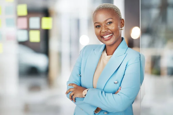 stock image Black woman, portrait smile and arms crossed in small business management leaning proud on glass at office. Happy African American female smiling in confidence for corporate planning at workplace.