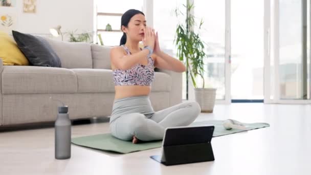 瞑想や家庭用のオンラインクラス フィットネスやワークアウト 総合的な健康と健康のタブレットを持つ女性 ラウンジウェブチュートリアルで手 またはピラティスのトレーニングを祈るアジア人 — ストック動画